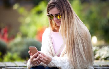 Genç kadın bahçede istimal hareket eden telefon