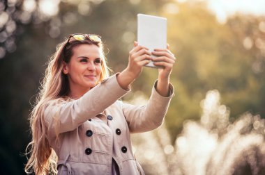 Tablet bilgisayar açık kullanarak şehirde modern kadın