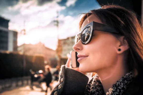 Cidade cena por do sol, mulher falando no telefone celular na rua — Fotografia de Stock