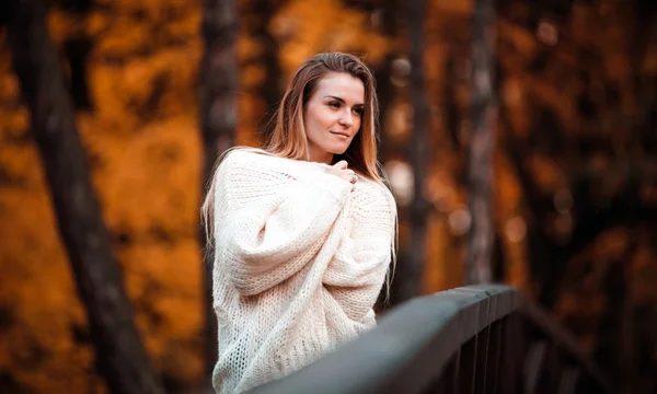 Красивая женщина в свитере наслаждается яркой осенью — стоковое фото