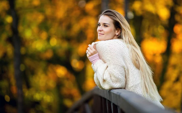 Красивая женщина в свитере наслаждается яркой осенью — стоковое фото