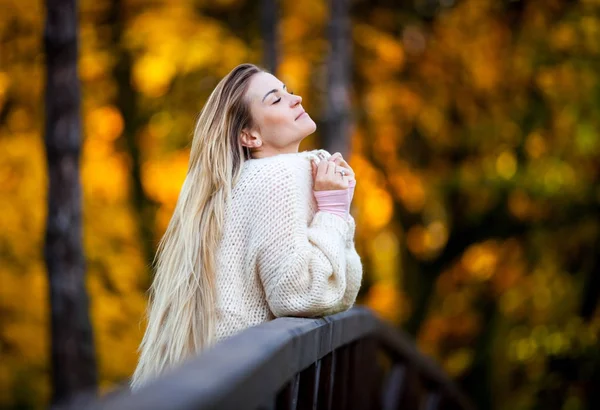 Vacker kvinna i tröja njuta av färgglada hösten — Stockfoto