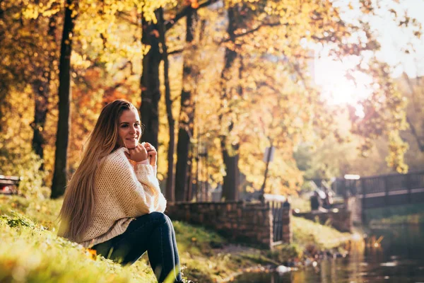 Mujer relajada junto al lago en el colorido parque otoñal —  Fotos de Stock