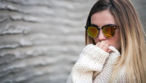 Lány jelentő előtt betonfal napszemüveg — Stock Fotó