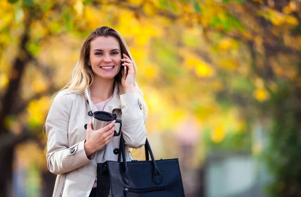 Mooie vrouw praten smartphone kleurrijke herfst wandelen straat — Stockfoto