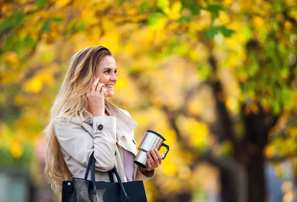 Mooie vrouw praten smartphone kleurrijke herfst wandelen straat — Stockfoto