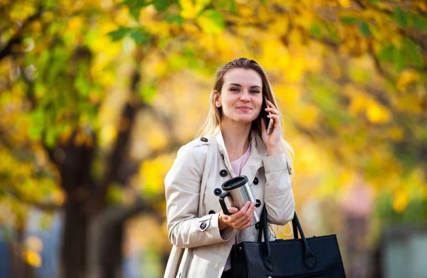 Красивая женщина говорит смартфон ходьба красочные осенние улицы — стоковое фото