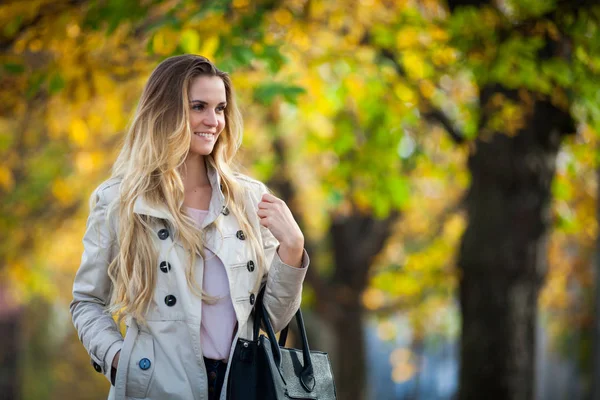 Gladlynt kvinna promenader i staden under färgglada höstträd 2 — Stockfoto