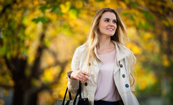 Veselá žena chůze ve městě pod barevné podzimní stromy 2 — Stock fotografie