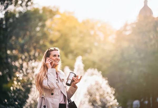 Mujer moderna en carrera caminando por la calle utilizando el teléfono inteligente al aire libre —  Fotos de Stock