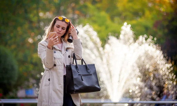 Mulher moderna em pressa andando na rua usando smartphone ao ar livre — Fotografia de Stock