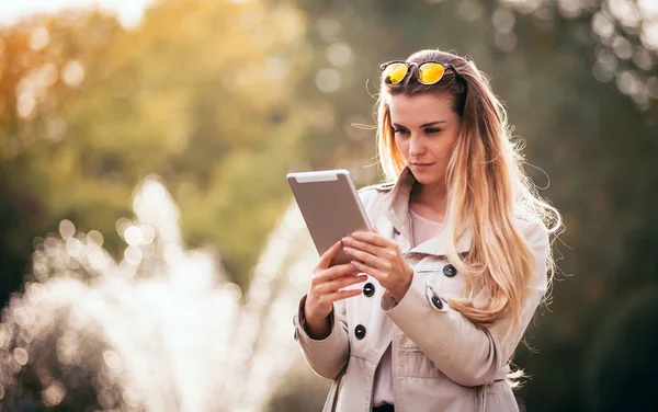 Mujer moderna en la ciudad usando tableta al aire libre —  Fotos de Stock