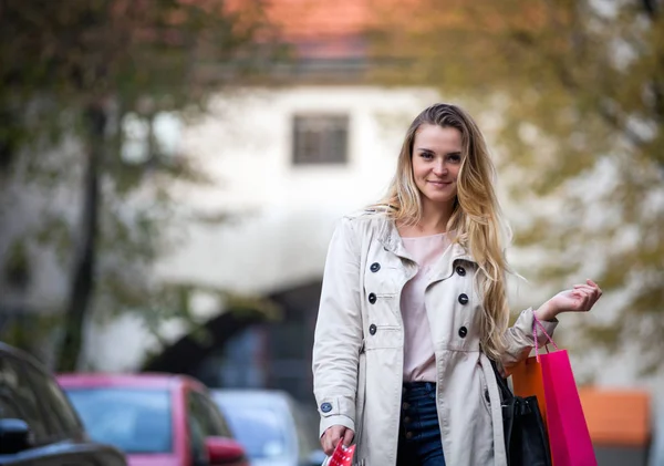 Žena s nákupníma taškama po ulici, neformální den — Stock fotografie