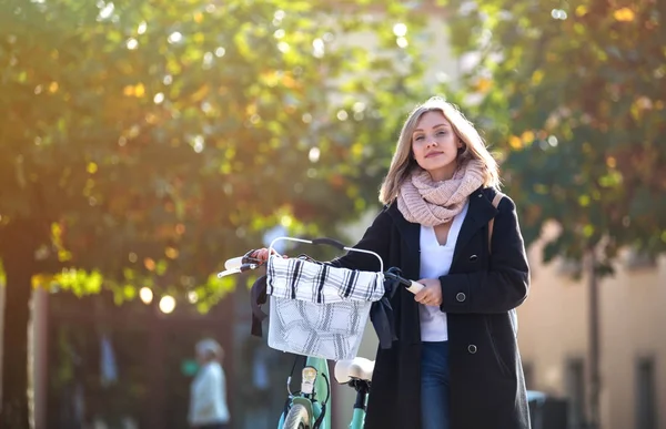 Flicka med cykel i staden under hösten — Stockfoto