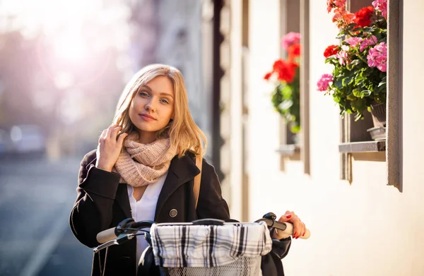 Donna in bicicletta in città, paesaggio urbano — Foto Stock