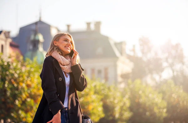 Woman talking on phone at the city street during autumn — Stock Photo, Image
