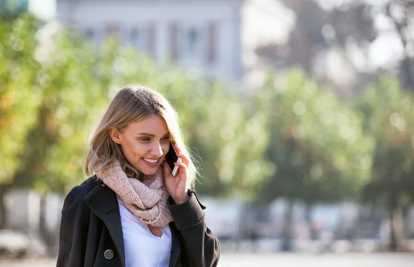 Ung kvinna med telefon på city gatan — Stockfoto