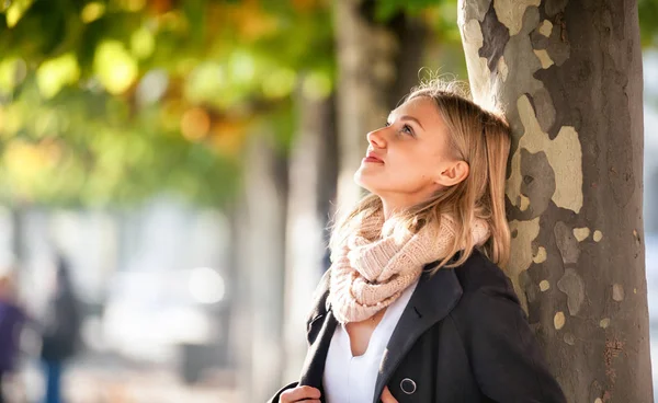 Donna sotto colorate foglie autunnali durante la passeggiata in città — Foto Stock