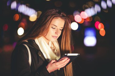 Güzel kadın tablet şehirde gece kullanma.