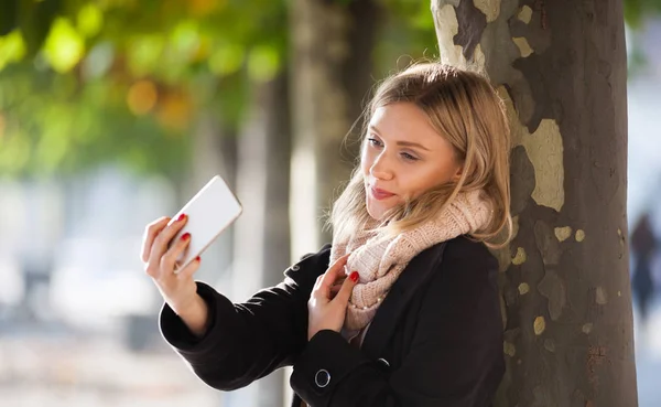 Pořizování fotografií s mobilním telefonem během podzimu v městě dívka — Stock fotografie