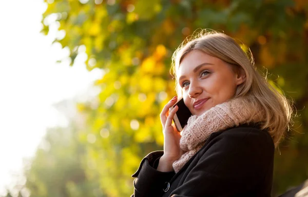 Mulher falando no telefone ao ar livre na rua durante o dia de outono — Fotografia de Stock