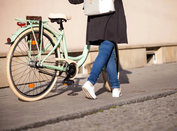 Девушка с велосипедом в городских пейзажах — стоковое фото
