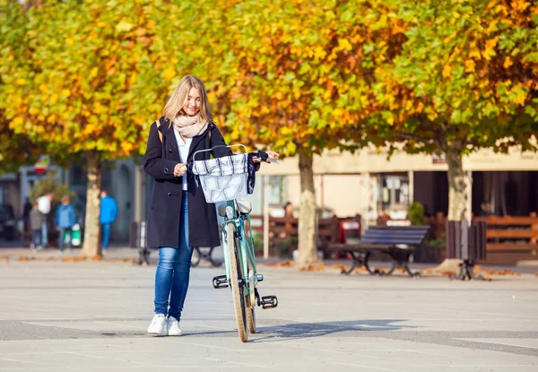 Kobiety z rocznika roweru na miasto jesienią — Zdjęcie stockowe