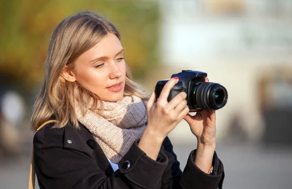 Tourist girl taking picture with camera during walk in the city — Stock Photo, Image
