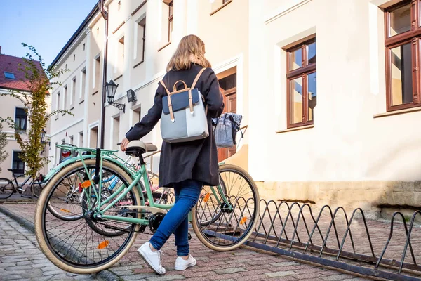 Flicka parkering hennes vintage cykel på gatan i gamla stan — Stockfoto
