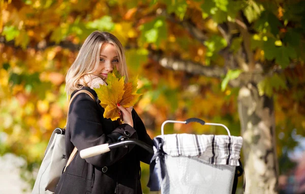 Vrouw met vintage fiets onder kleurrijke herfst bomen in de stad — Stockfoto