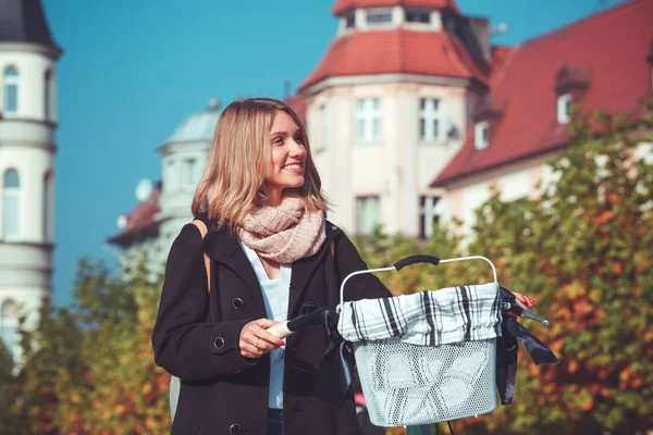 Giovane donna con bici vintage nella città autunnale — Foto Stock