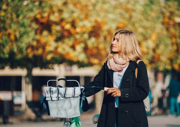 Giovane donna con bici vintage nella città autunnale — Foto Stock