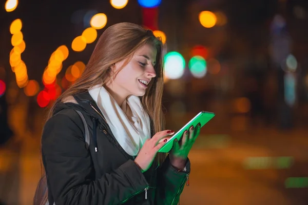 Женщина использовала планшетник в городе по ночам — стоковое фото