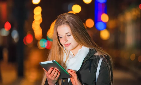 Hermosa mujer usando tableta en la ciudad por la noche —  Fotos de Stock