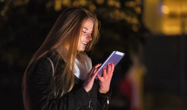 Женщина использовала планшетник в городе по ночам — стоковое фото