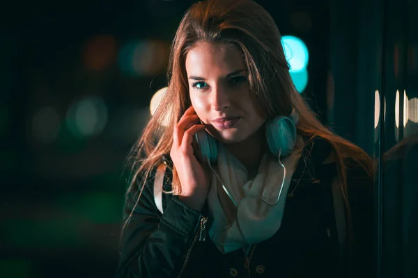 Schöne Frau mit Kopfhörern in der Nacht in der Stadt — Stockfoto