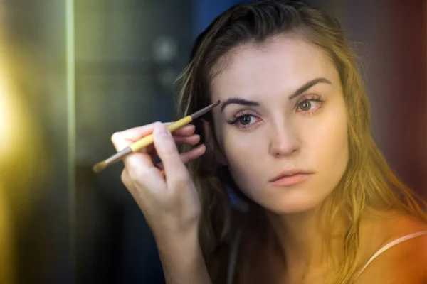 Schläfrige Frau beim morgendlichen Make-up im Badezimmer, authentisches Porträt — Stockfoto