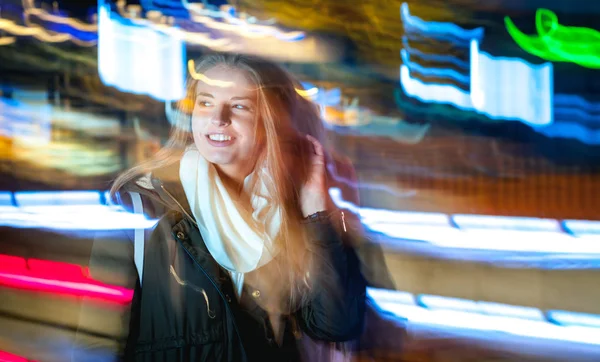 Женщина в городе ночью среди неоновых движущихся огней — стоковое фото