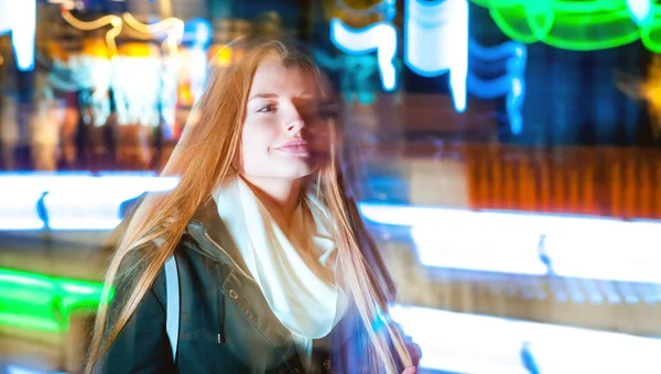 Mujer en la ciudad por la noche entre luces móviles de neón —  Fotos de Stock
