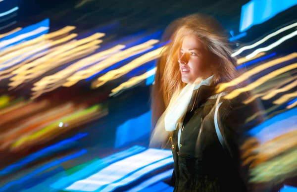 Mujer en la ciudad por la noche entre luces móviles de neón — Foto de Stock