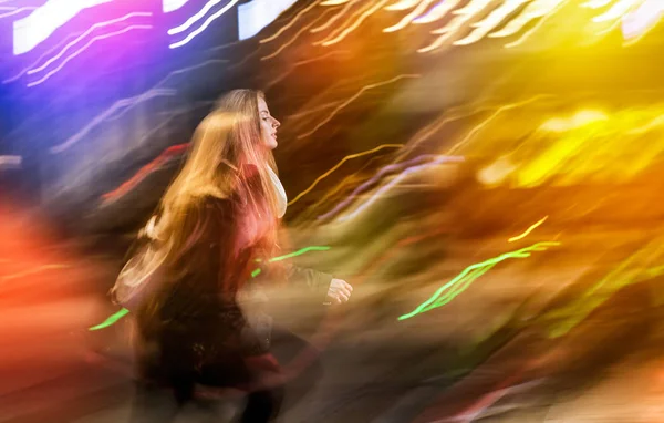 Mujer en la ciudad por la noche entre luces móviles de neón —  Fotos de Stock