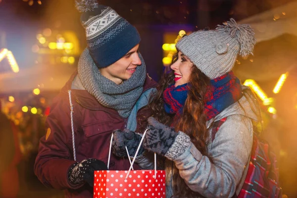 Para z torby na zakupy na tradycyjny jarmark bożonarodzeniowy, wakacje, zakupy — Zdjęcie stockowe