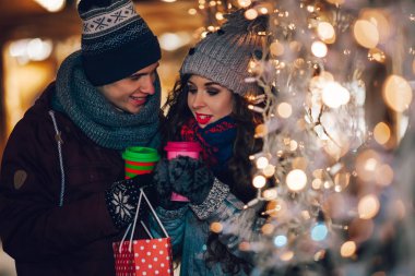 Çift sıcak zevk colorul Noel pazarı, bokeh ışıklar arka plan elbise