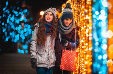 Noel'de hediye çanta ile çift arka plan şehirde akşam yürüyüş, ışıklar