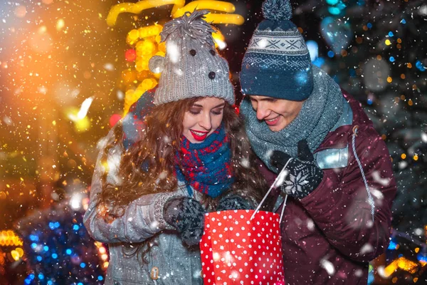 Muž dává romantický dárek pro svou přítelkyni, Vánoční trh na zasněžený večer — Stock fotografie