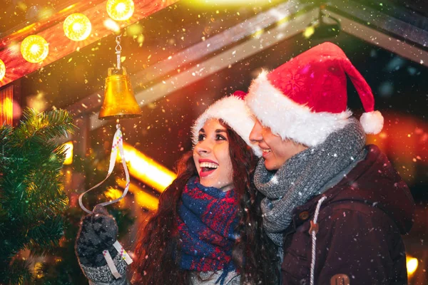 Liebendes Paar genießt märchenhaften Weihnachtsmarkt, Schneefall am Abend — Stockfoto