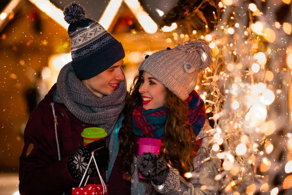Couple en vêtements chauds appréciant colorul marché de Noël, bokeh lumières fond — Photo