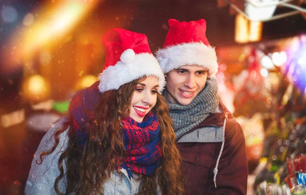 Casal no mercado de Natal escolher brinquedos para comprar — Fotografia de Stock