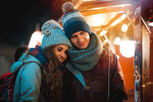 Weihnachtsmarkt am Abend, Paar in märchenhafter Umgebung — Stockfoto