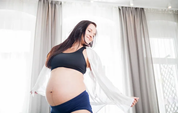 Joyeux sourire femme enceinte à la maison dansant près de la fenêtre — Photo